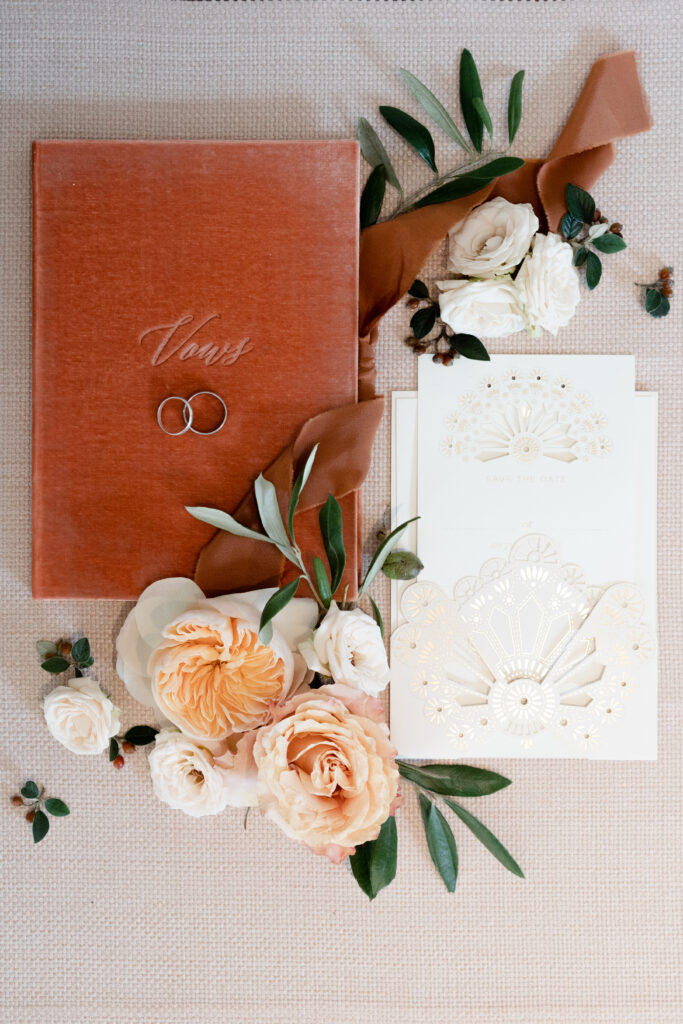 vow book, rings and wedding stationery displayed in a pretty flatlay