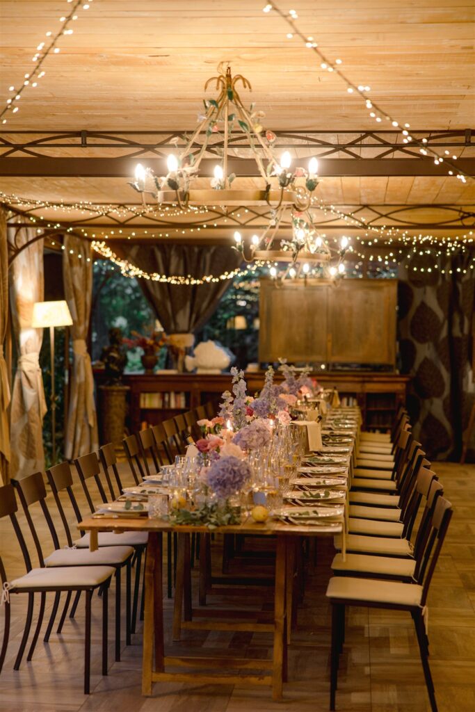 Italian wedding dinner set up inside under twinkling lights