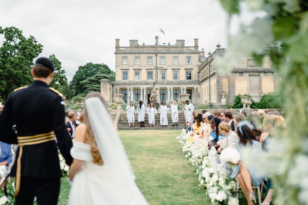 A surprise gospel choir sings at Cici and Hugo's Somerley House wedding, with the house in the background