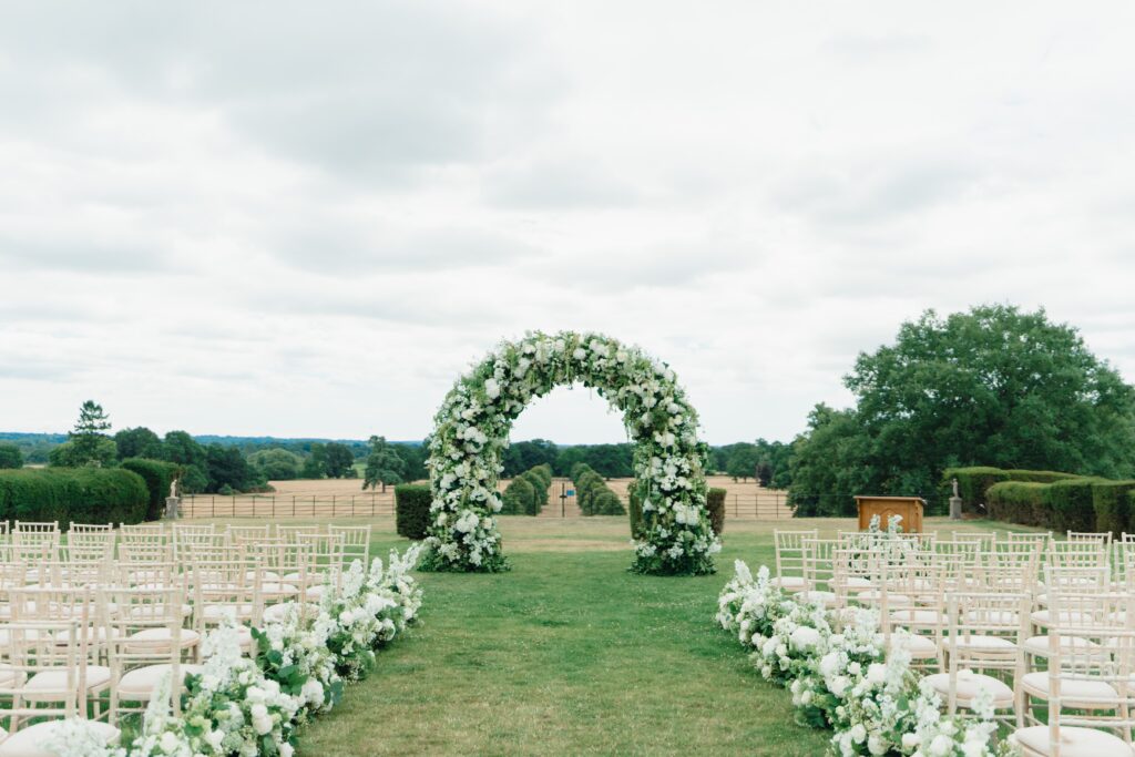 A white floral ceremony arch for a Somerley House wedding