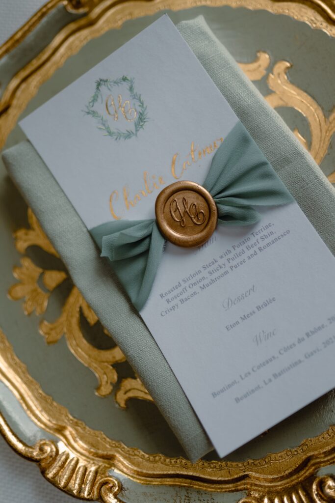Menu cards with blue-green napkins and charger plates at a Somerley House wedding