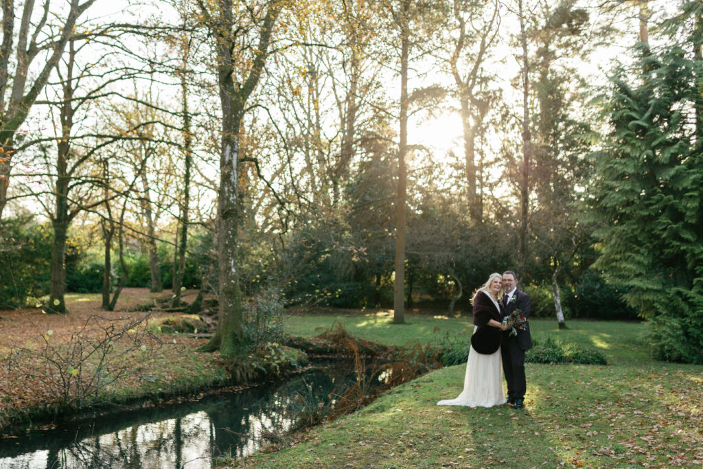 Couple pose by the lake at a short notice winter marquee wedding planned at couple's home by Ella Hartig