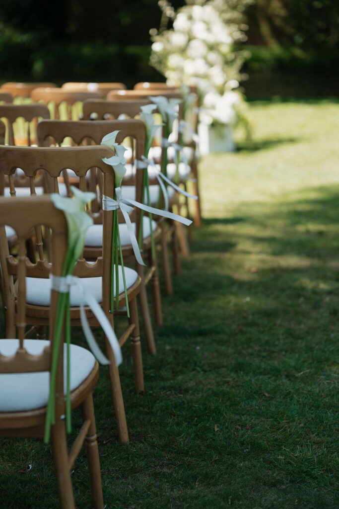 calla lilies on wedding ceremony chairs with ribbons.