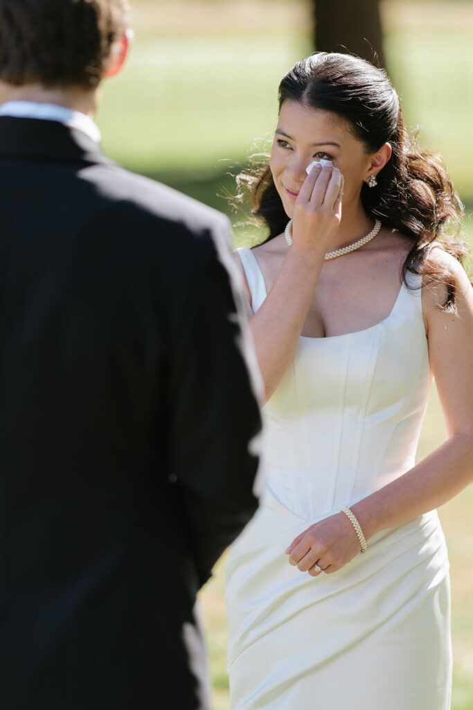 emotional moments in a wedding ceremony, bride wipes away a tear