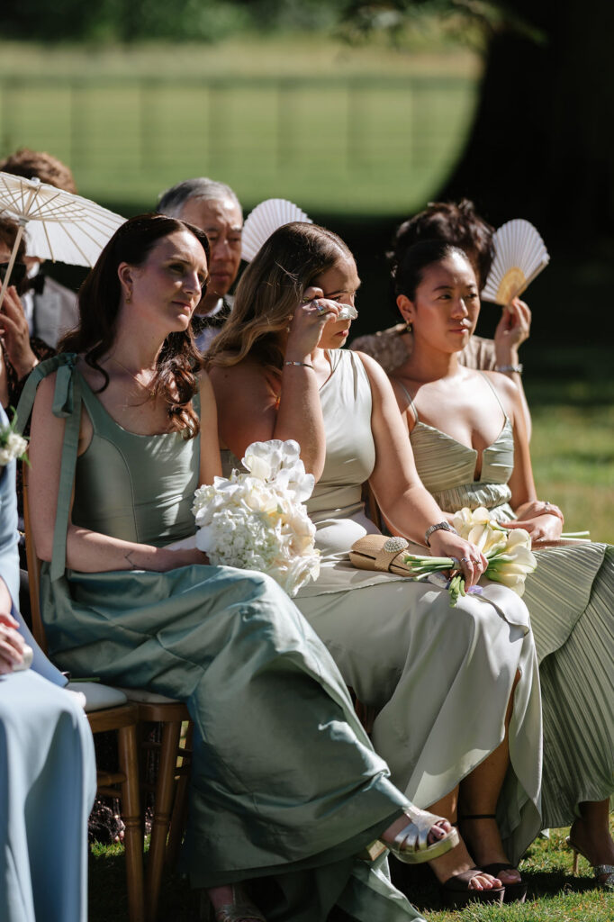 emotional moments in a wedding ceremony, bridesmaid wipes away a tear